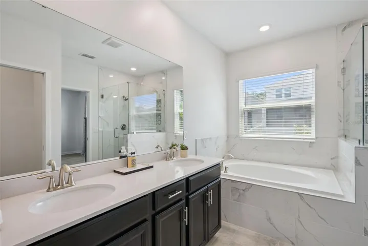 Primary bath with dual sinks, tub, and separate shower