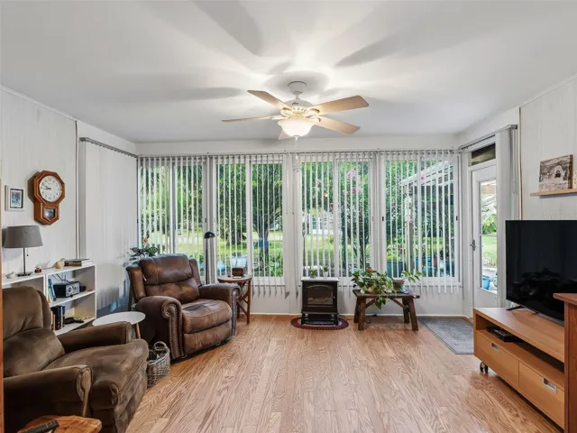 BRITGHT FLORIDA ROOM/DEN WITH NEWER WINDOWS AND REAL WOOD FLOORS