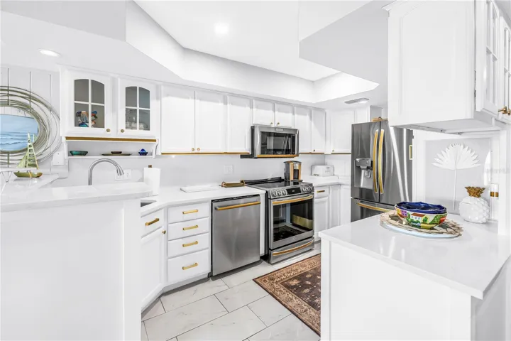 Light and bright kitchen with stainless steel appliances w/ gold accents throughout
