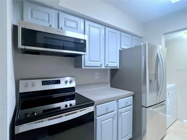 Kitchen- microwave, range & fridge on left