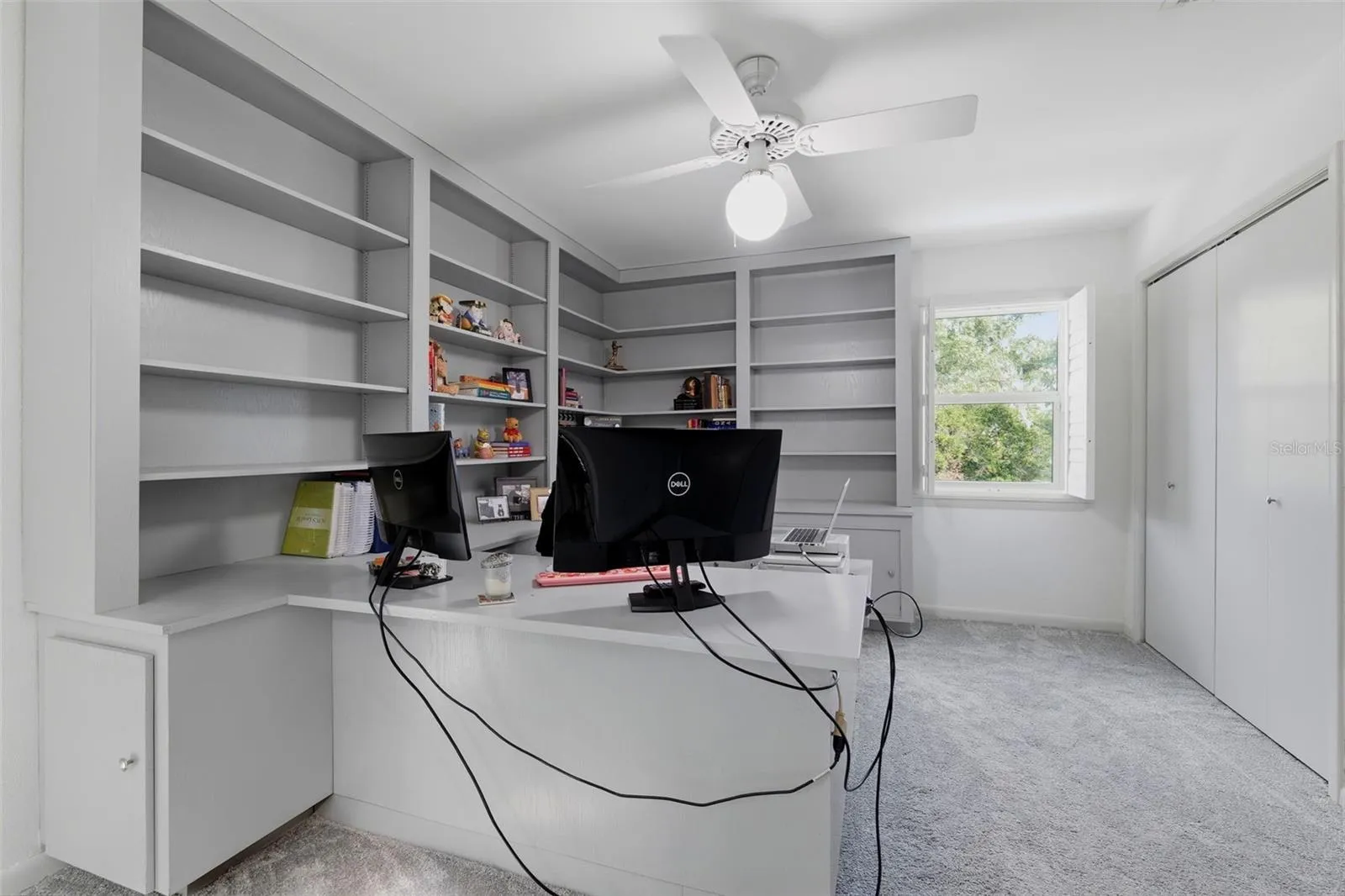 Upstairs bedroom currently being used as an office with built-in desk and cabinetry