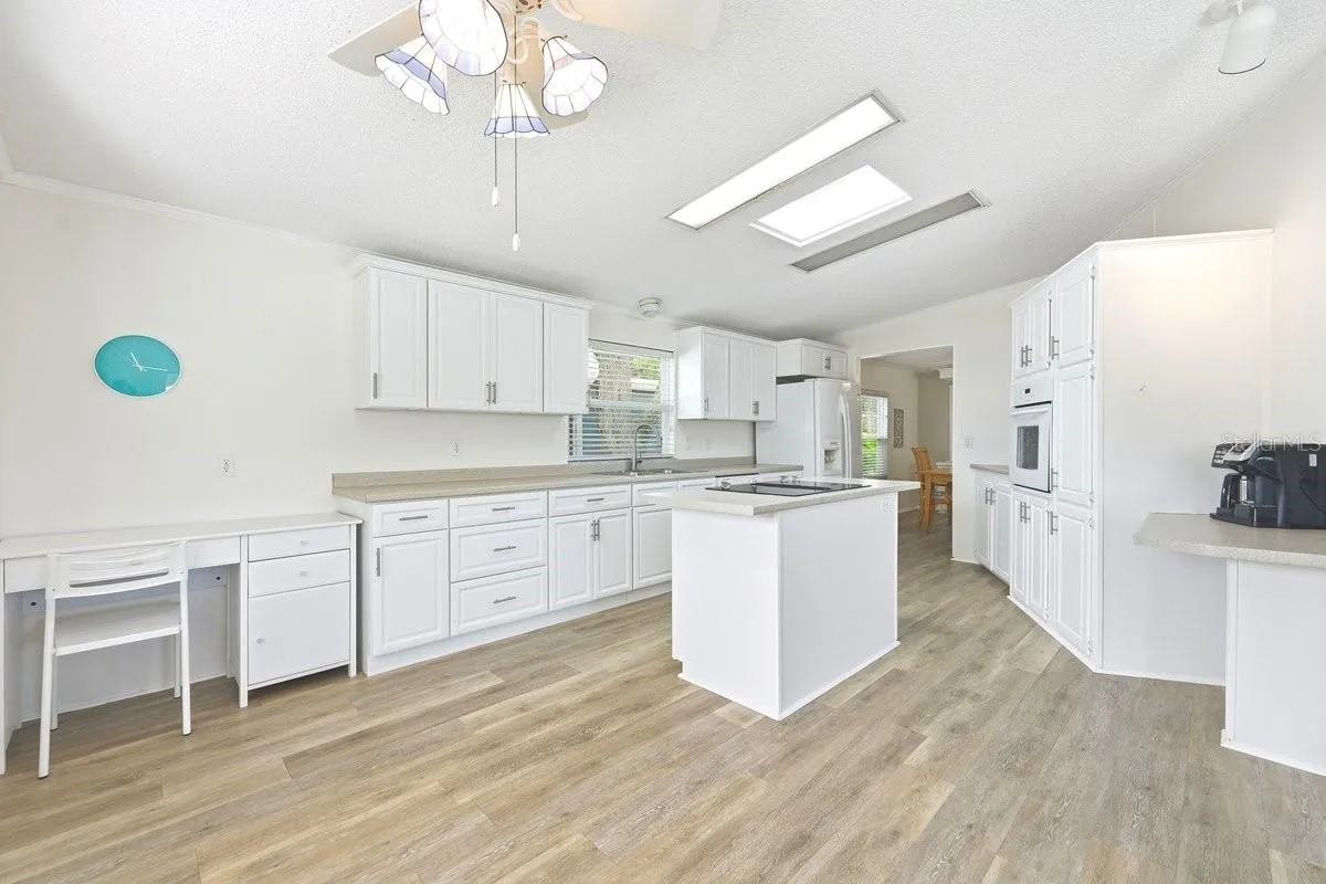 Current owner also has a desk in this spacious kitchen. This view is taken from the dinette area.