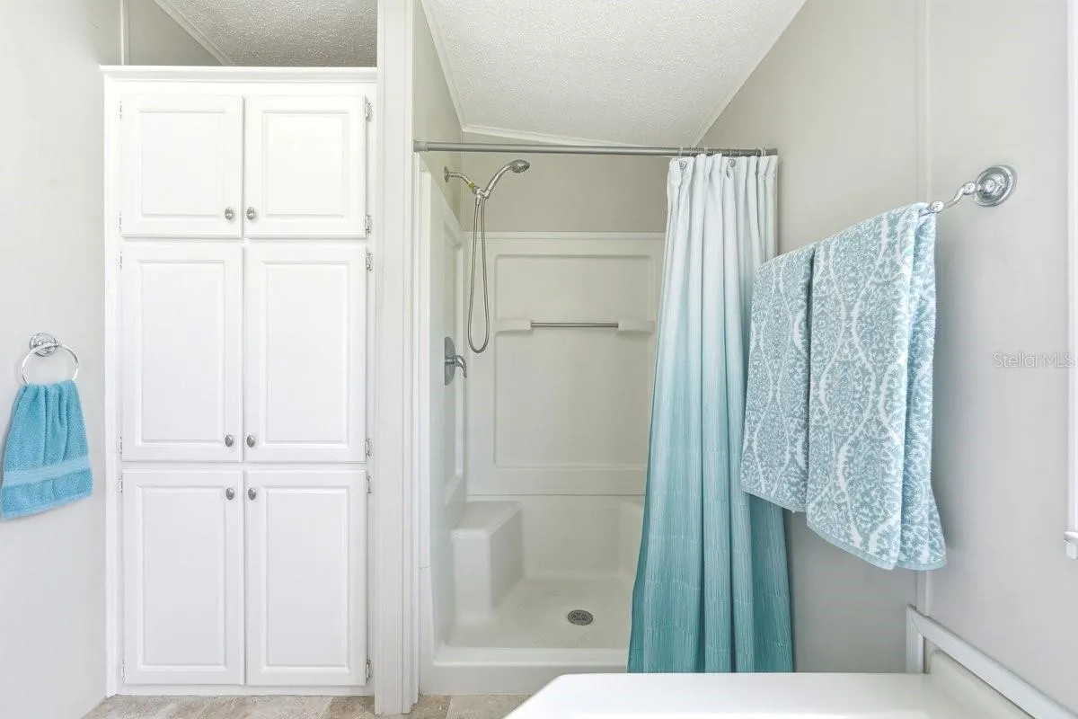 View from Tub showing Shower with seating and Linen closet