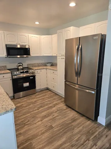 Kitchen with microwave hood, slide in range and refrigerator with french doors and bottom drawer freezer