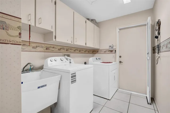 Indoor laundry with utility sink leading to the 2-car garage~