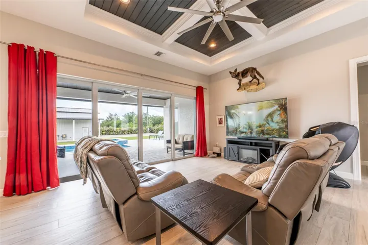 Another look at the expansive living room, emphasizing the wall of multi-slide glass doors that completely open to the pool deck. Experience the absolute best of true Florida indoor-outdoor living from the comfort of this light-filled, open-concept great room.