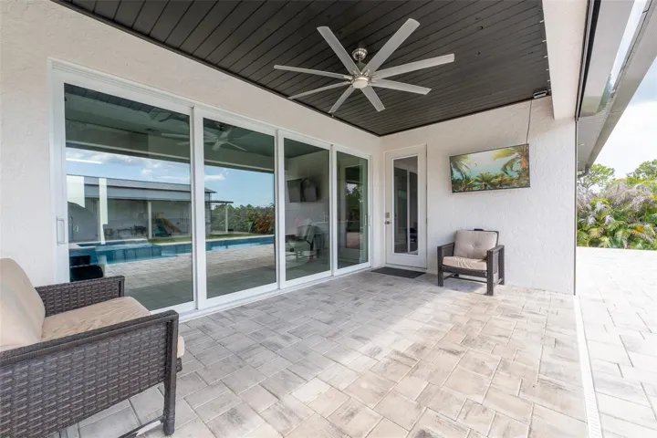 The covered lanai is an entertainer’s dream, featuring a sophisticated dark tongue-and-groove ceiling inlay, a massive modern ceiling fan, and seamless transitions into the main house via oversized sliding glass doors. Ideal for watching the game or enjoying the Florida breeze in the shade.