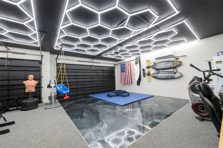 Prepare to be amazed! The attached multi-car garage has been meticulously transformed into a world-class home gym and recreation center. It features a jaw-dropping custom hexagon LED grid ceiling lighting system, a dedicated mini-split AC system for perfect climate control, and insulated black garage doors.