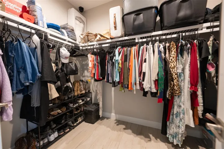 Storage galore! The massive walk-in primary closet features wrap-around ventilated shelving and custom hanging racks. With an abundance of space for clothing, shoes, and luggage, this walk-in wardrobe is a homeowner's dream.