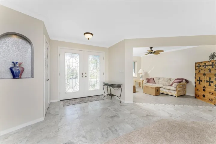 Expansive entry showcases beautiful porcelain tile with custom arched niche and sitting room