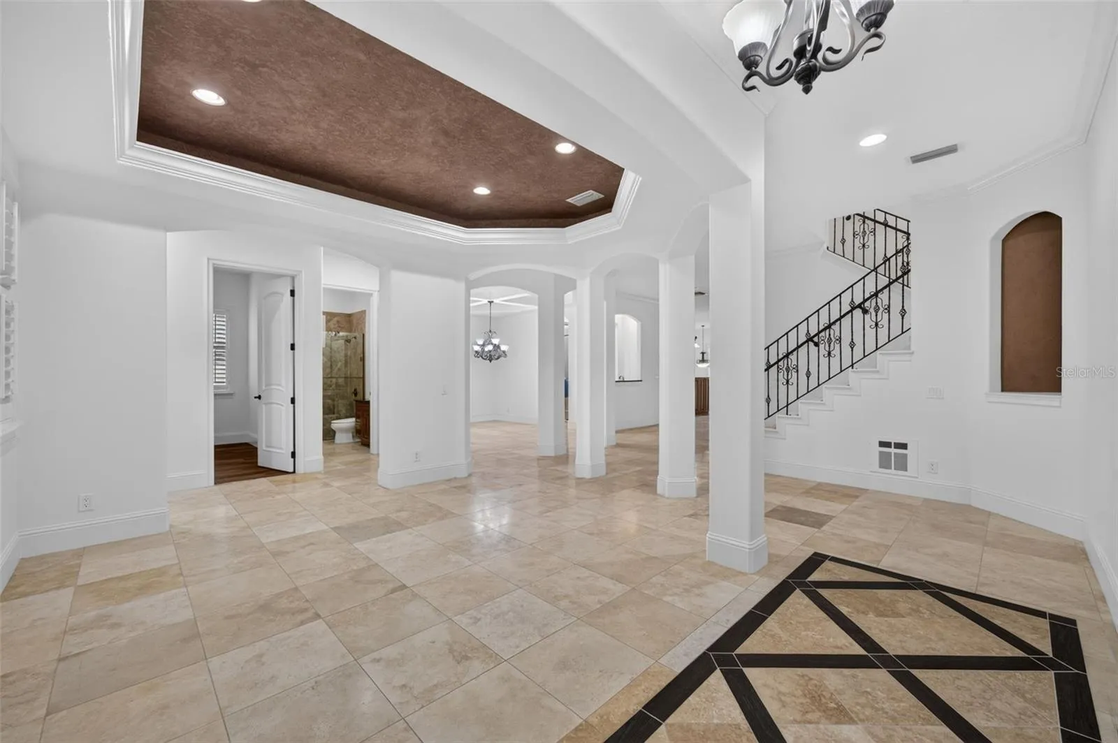 Living Room features a tray ceiling, travertine flooring & high ceilings