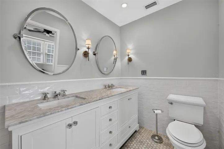 Gorgeous updated Primary Bathroom showcasing marble flooring, dual sinks & quartz countertops