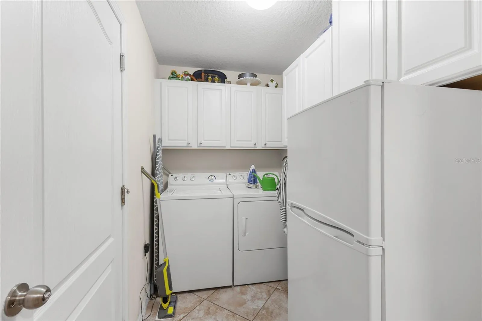 Laundry room with bonus refrigerator/freezer and cabinets for storage