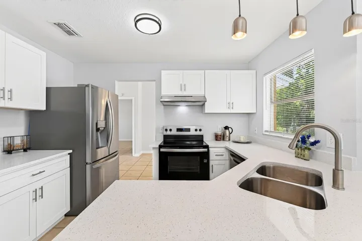 The heart of the home is the brand-new kitchen, tastefully designed with solid surface countertops, abundant cabinetry, breakfast bar, NEW STAINLESS STEEL APPLIANCES, and a cozy breakfast nook.