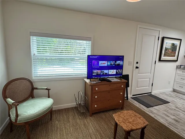 Smart TV with basic cable and large window overlooking parking and patio area.