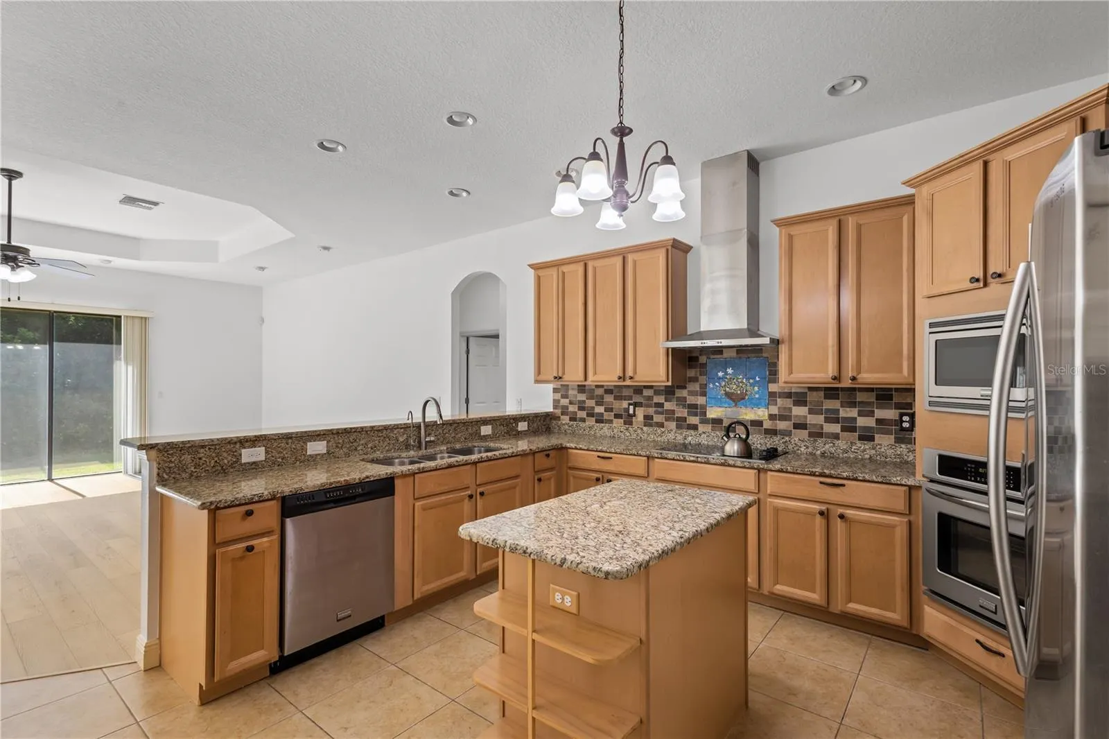 The spacious kitchen offers abundant cabinetry, generous workspace, and exceptional storage.