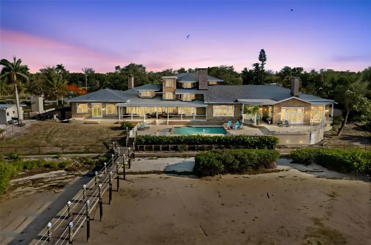 At dusk, views from the Manatee River beautifully frame the rear elevation of this magnificent mansion, casting the estate in a serene and dramatic waterfront glow.