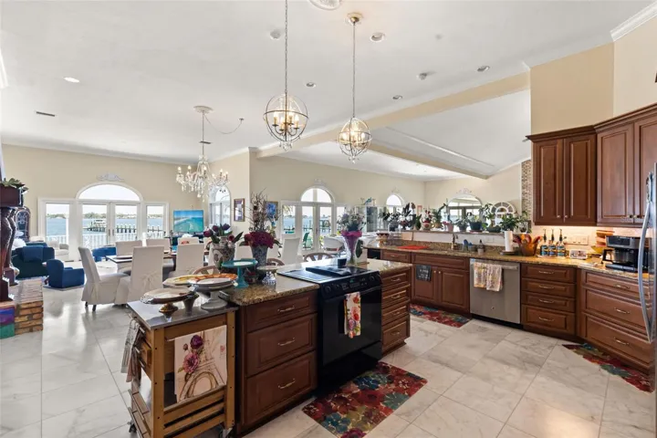 Designed for both luxury and flow, the chef's kitchen showcases stunning panoramic vistas of the Manatee River, extending effortlessly into the media room and grand ballroom.