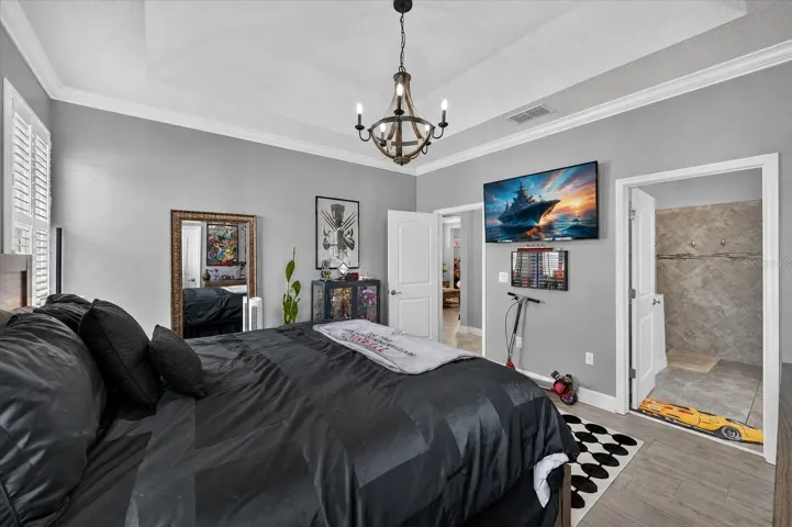 2465 Annacella Ave. -  Large master bedroom with elegant tray ceiling & chandelier