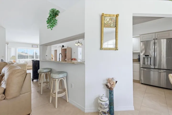 Bar Stools facing Kitchen. Huge Refrigerator with lower Freezer.