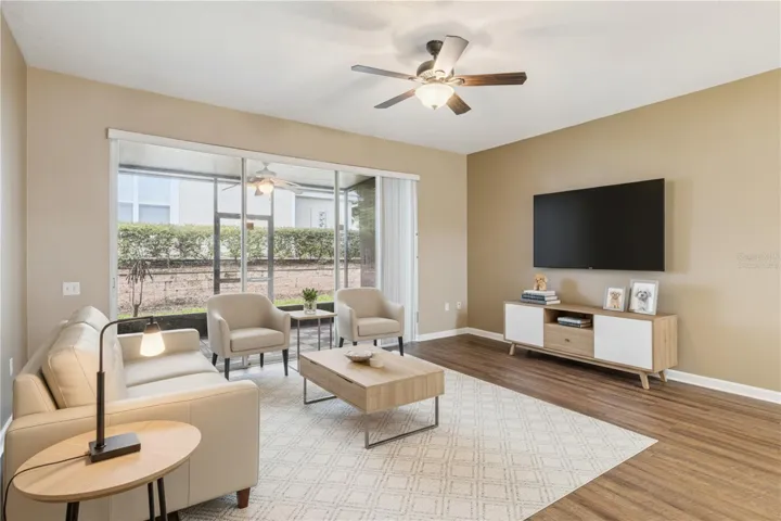 Virtually staged living room opens to a screened patio.