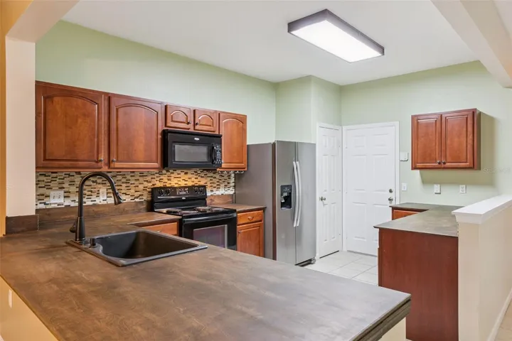 Kichen offers ample storage and a stained wood countertop.
