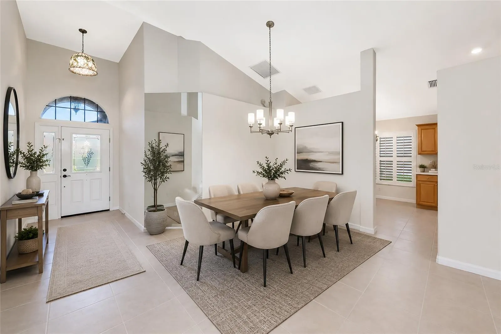Virtual staged. Cathedral ceiling over foyer and dining.