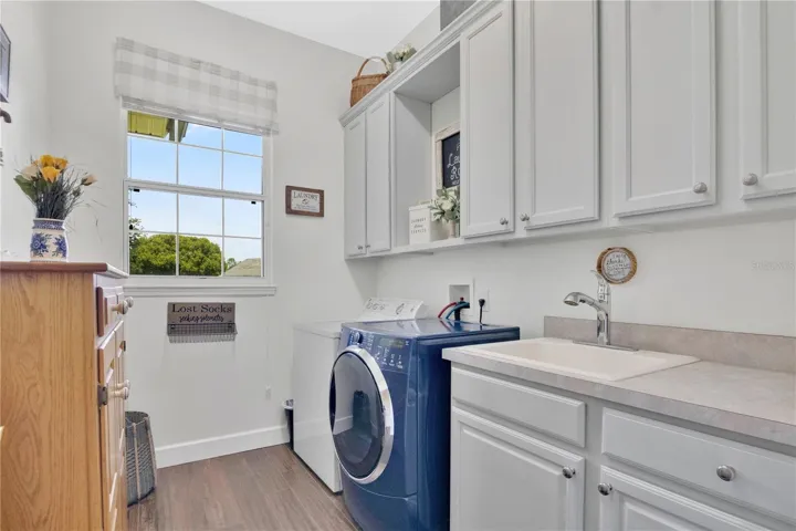 Large Laundry Room with SINK along with new upper cabinets and a lovely window.