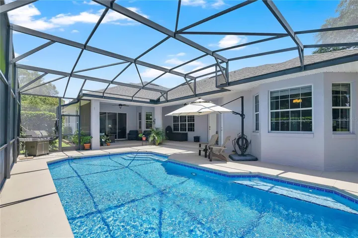 Stunning refreshing screened in pool surrounded by hedges for lots of privacy.