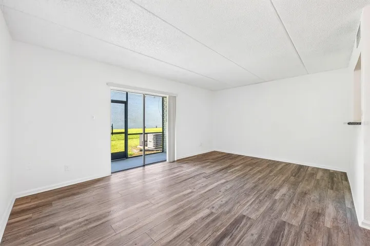 Living area has sliding glass doors that open up to the screened lanai.