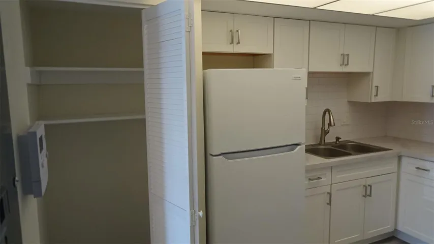 Pantry next to refrigerator