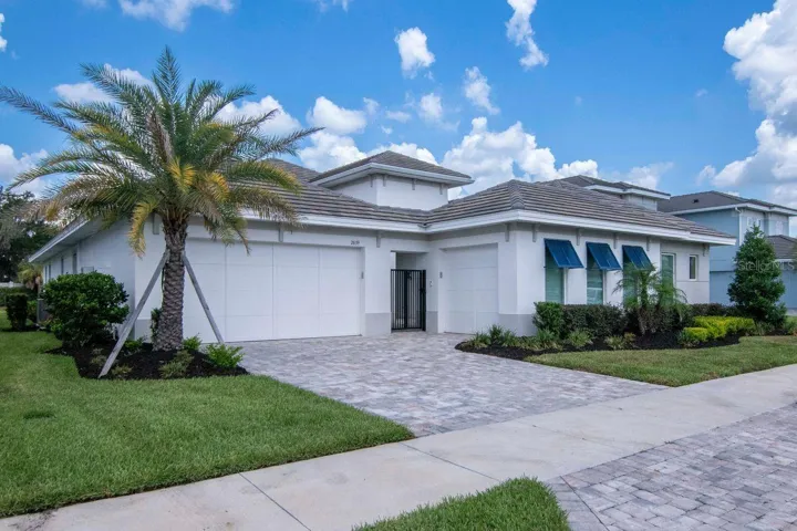 Front of Home - Paver Driveway - Tile Roof - Blue Decorative Shutters - Sidwalks - Landscaped