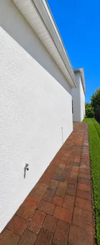 Right back side of garage with paver sidewalk leading to courtyard