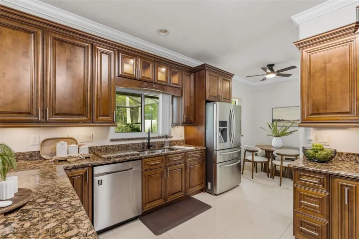 Chef's kitchen with stainless appliances - elegant cabinet detail -under cabinet lighting - glass transoms on cabinets