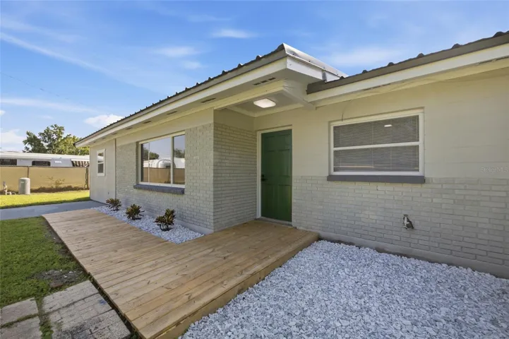 Wood deck leading to door from driveway.