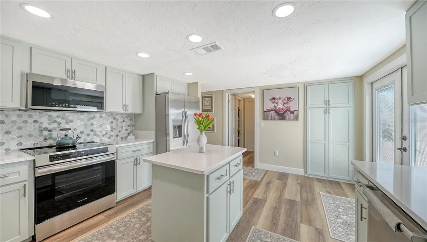 Large kitchen with Island counter space and cabinets.