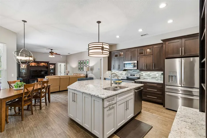 Enormous granite topped island is home to the Bosch dishwasher, counter height seating and lots of storage
