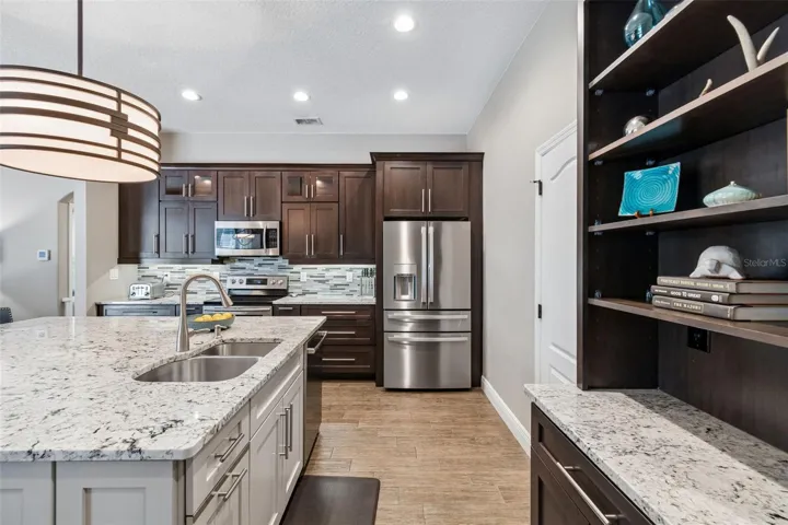 Dark rich wood cabinetry is a beautiful contrast to the lighter toned island which anchors the kitchen space