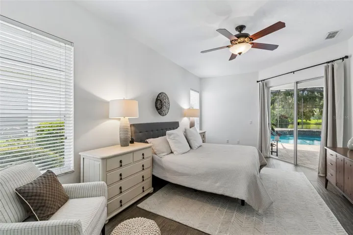 Peaceful primary suite with pool views and sitting area