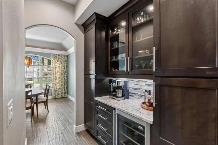 Dreamy coffee bar/butler's pantry includes a beverage fridge and plenty of rollout shelving for food storage.