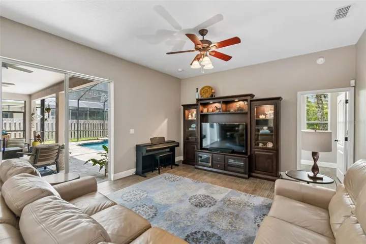 Spacious family room is open to the kitchen and has pool views