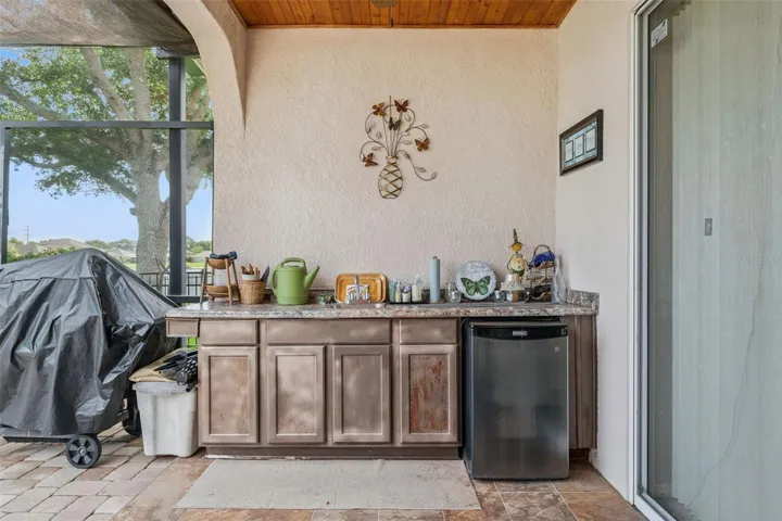 Patio equipped with an outdoor sink, built in countertop and mini refrigerator