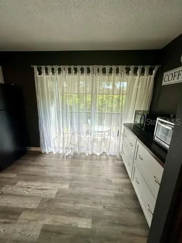 Kitchen view out to balcony.  Coffee and Tea bar with extra cabinetry, microwave and air fryer.