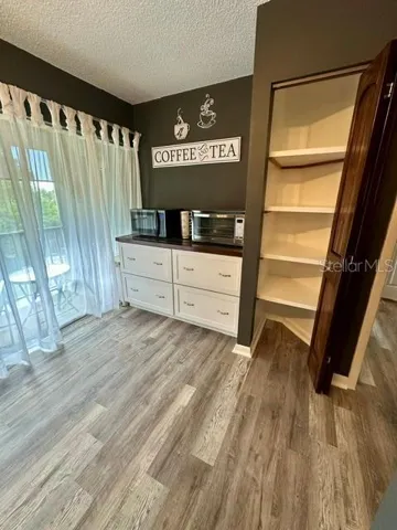 Coffee/Tea bar with exrea cabinetry, microwave and air fryer