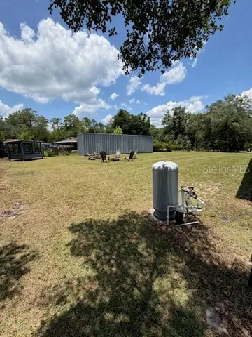 Yard with well, chicken pen, conex building for dry storage lockable and outdoor seating area