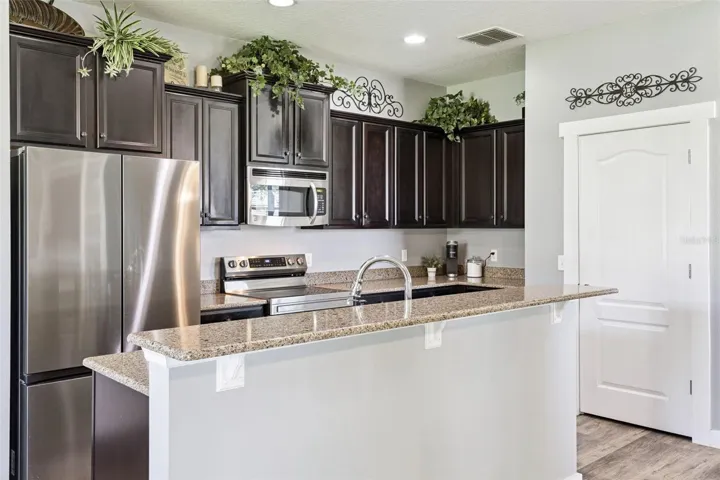 Quartz countertops, a breakfast bar, and strong workspace make the kitchen both functional and attractive.