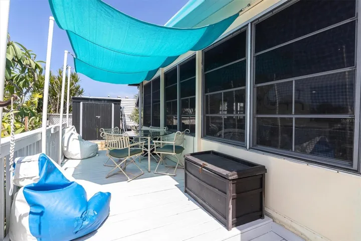 large Wood porch on the canal side, connected to the Florida room.
