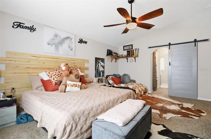 Beautiful fan and barn door leading to double walk in closets and ensuite