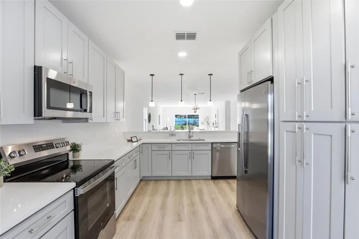 Galley-style kitchen view showing storage, appliance placement, and granite counter space.