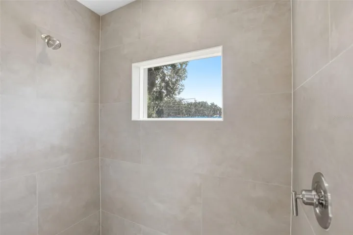 Walk-in shower with tile-look surround and modern fixtures in the primary bathroom.